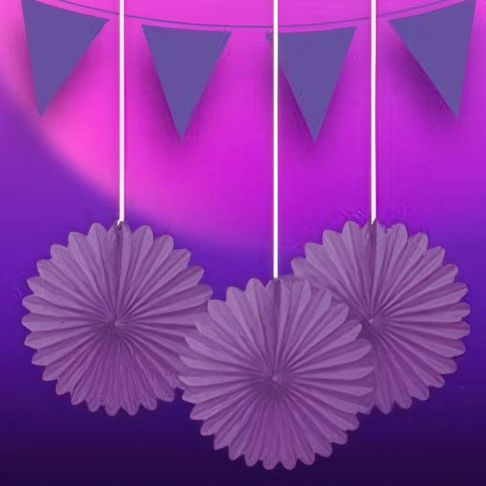Vibrant purple party decorations including hanging paper fans and banners for a luxurious celebration