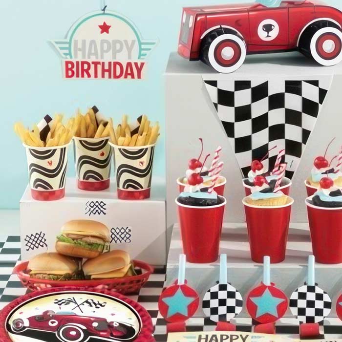 Vintage Race Car Party Decorations with checkered flags, themed tableware, and festive treats for a birthday celebration